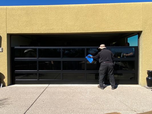 gorgeous black glass garage door being cleaned